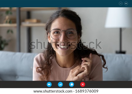 Headshot portrait screen view of smiling millennial woman in glasses sit on couch at home talk on video call with relatives, happy young female have Webcam conversation, take online course indoors Royalty-Free Stock Photo #1689376009