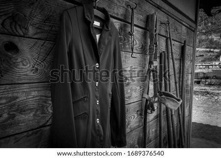 
Horse riding jacket hanging on a wooden wall