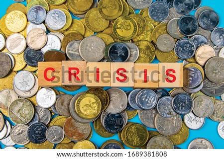 Coin with Wooden blocks text CRISIS Business and finance concept.