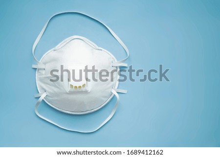 White face medical mask against virus, flu and coronavirus isolated on light blue background Royalty-Free Stock Photo #1689412162