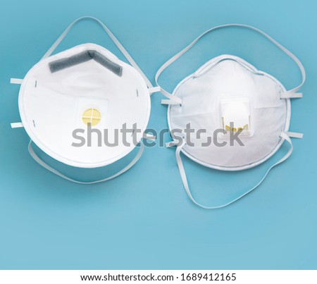 White face medical mask against virus, flu and coronavirus isolated on blue background Royalty-Free Stock Photo #1689412165