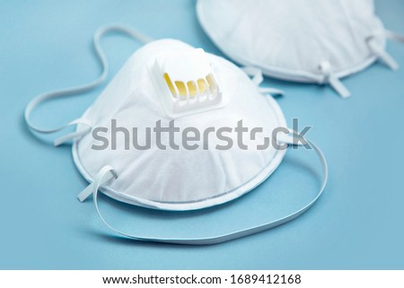 White face medical mask against virus, flu and coronavirus isolated on blue background Royalty-Free Stock Photo #1689412168