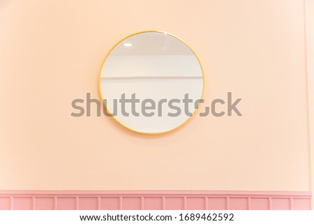 round mirror in sweet pastel room.
