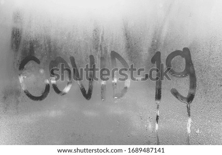 coronavirus, the inscription covid 19 on the foggy window is a symbol of respiration and resistance to the virus