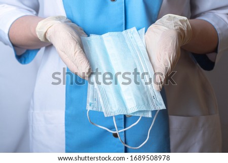 The nurse holds protective face masks in her hands. Hands are wearing disposable medical gloves. Remedies for viruses, diseases, flu and coronavirus
 Royalty-Free Stock Photo #1689508978