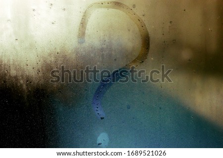 Question mark word handwritten on the wet foggy window. Autumn rain. Unclear feeling