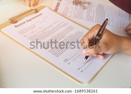 Closeup of customer signing contract of rental agreement of the new property on the table at the office. Professional and successful business discussion, and closing sales concept