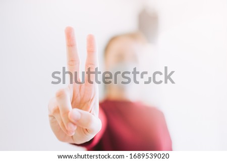 Covid19 Coronavirus symptoms.Asian woman girl stay at home for protect from Coronavirus covid-19.hands showing victory sign gesture and fight Covid-19 virus outbreak.wfh is work from home save lives. 
