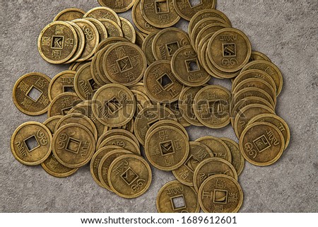 Oriental old coins lying on the stone floor Royalty-Free Stock Photo #1689612601