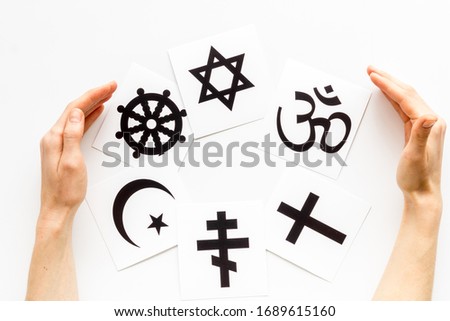 World religions concept. Hands hugs Christianity, Catholicism, Buddhism, Judaism, Islam symbols on white background top view