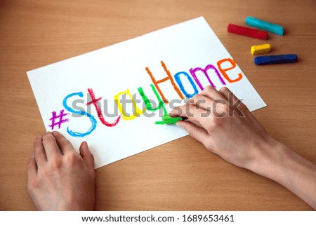 A children is drawing  "Stay home" sign