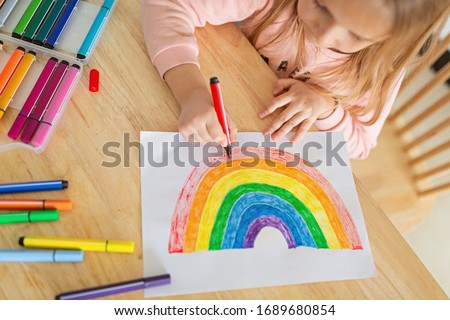 Kid painting rainbow during Covid-19 quarantine at home. Stay at home Social media campaign for coronavirus prevention, let's all be well, hope during coronavirus pandemic concept