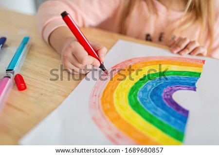 Kid painting rainbow during Covid-19 quarantine at home. Stay at home Social media campaign for coronavirus prevention, let's all be well, hope during coronavirus pandemic concept
