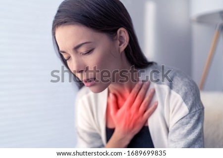 COVID-19 shortness of breath Coronavirus cough breathing problem. Asian woman touching chest in pain with red highlighted area. respiratory symptoms fever, coughing, body aches. Royalty-Free Stock Photo #1689699835