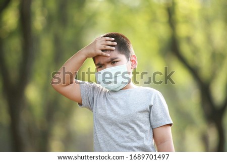 A young Asian boy , 7 Years Old , wear mask to protect virus covid-19 and germs Royalty-Free Stock Photo #1689701497