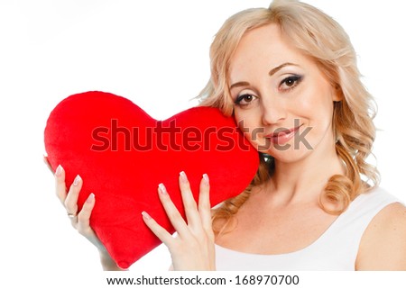 portrait of Pregnant woman's belly with heart shaped red pillow valentine in her hands