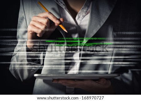 business woman looks edits binary code on a Tablet PC, the concept of information security