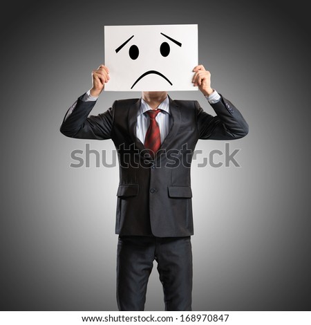 business man holding a poster with a painted face on it instead of a face, the concept of duplicity in business