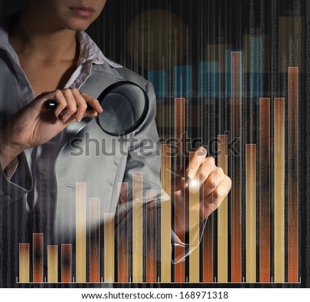 business woman draws a graph with a magnifying glass on the screen tich binary code