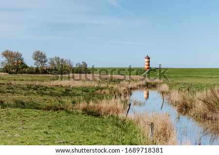 The famous Pilsum Lighthouse around Krummhoern in East Frisia, Germany Royalty-Free Stock Photo #1689718381