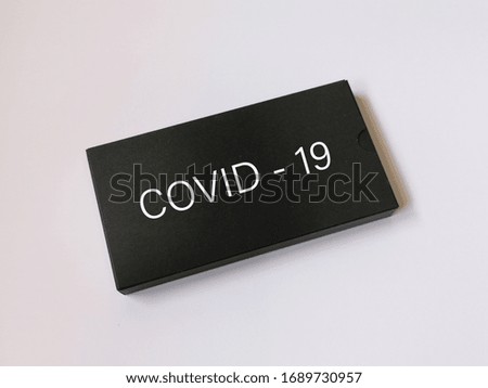 Covid-19 word written on top of the black box isolated on white background. 