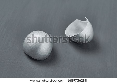 Silver egg shells on dark concrete background. Concept of easter, pricelless ideas, successful business investment or luxury breakfast