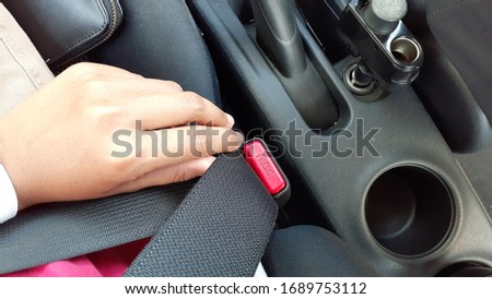 Hand trying to pull in the safety seat belt.