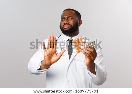 Flu, disease, healthcare and medicine concept. No thank you. Portrait of skeptical african-american doctor avoid homeopathy, showing real working pills and medication, show stop rejection sign