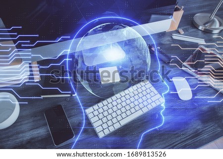 Double exposure of table with computer and brain hologram. Data innovation concept.