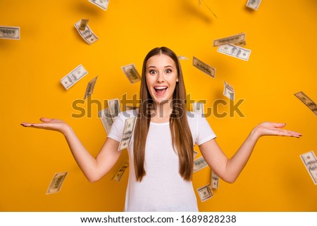 Portrait of astonished positive girl hipster enjoy rejoice money fall fly hold hands impressed scream wow omg wear white t-shirt isolated over bright shine color background