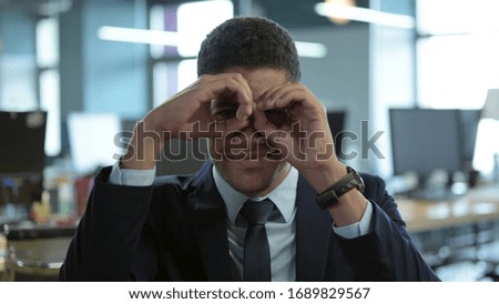 Portrait of African Businessman making Binocular with Hand Gesture