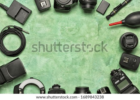 Frame made of modern photographer's equipment on color background