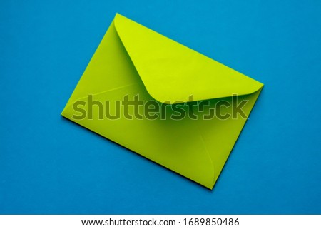 
Green Envelope on a Blue Background. Postal envelope. Love letter. Colorful photo of the postal envelope.