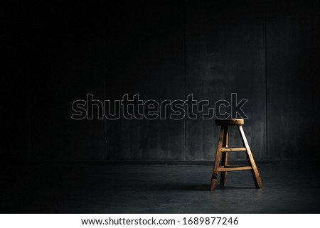 Ancient wooden chair saith against dark background
