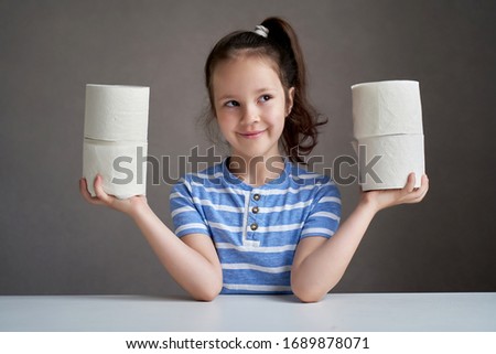 beautiful girl sitting at the table and toilet paper in short supply