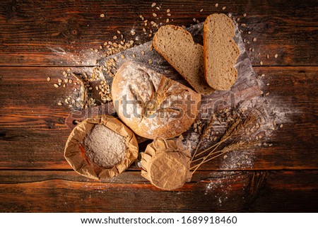 Above view of a rustic loaf of bread on an old wooden table.