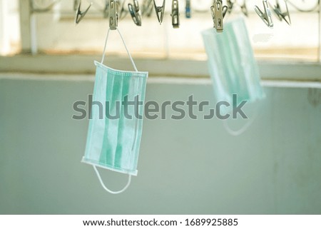 Disposable medical mask hanging on pegged clothesline for reused in some case, Due to lack of disposable medical mask of novel coronavirus (COVID-19) situation.
