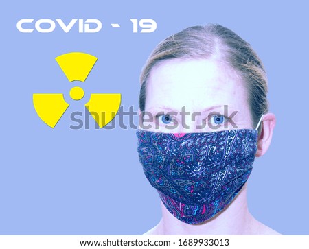 A woman's face with a handmade medical mask close-up isolated on a blue background. Free space for text. Horizontally