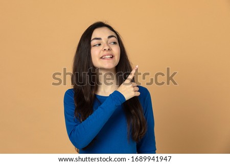 Brunette young girl wearing blue jersey on a blue background