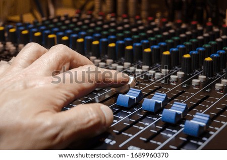 Man's hand controlling sound mixer