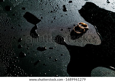 Wedding rings on a chrome plated surface. Water drops with reflections of light.Soft focus. Advertising photo for jeweler. Water Bubbles