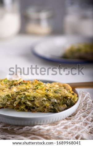 Kitchen table served with white cabbage casserole with chicken and eggs in a plate Royalty-Free Stock Photo #1689968041