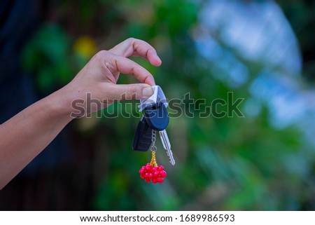 Asian women holding dirty car keys with napkin.