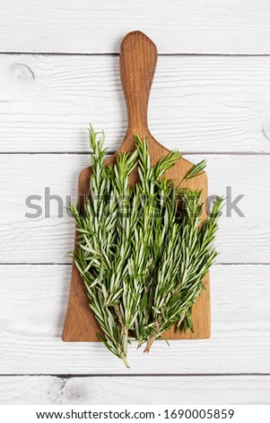 Cut board with rosemary on white wood background. Top view, flat lay, concept of food ingredient picture