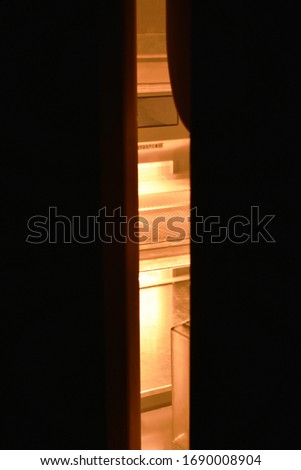 light sift out from refrigerator door ajar out in the dark