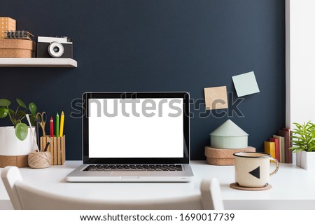 Home office with laptop stationery, cactus and books near navy blue wall. Home learning concept. Trendy, creative desk. Royalty-Free Stock Photo #1690017739