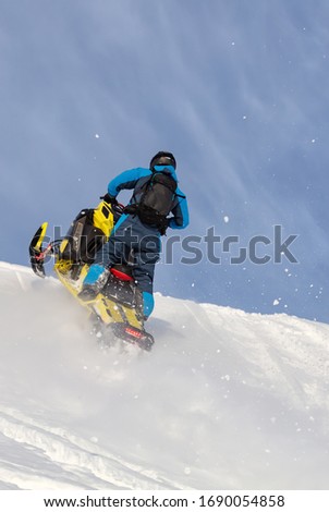 jump on a mountain snowmobile from a high ledge with the descent of a large avalanche. snowmobilers sports riding. Winter extreme. testing of a new model of mountain snowmobile, prototype 2021