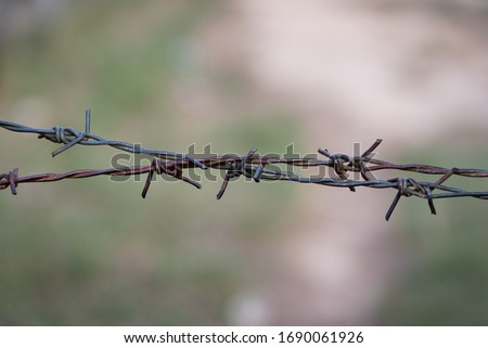 Barbed wire also known as barb wire. It is used to construct inexpensive fences and is used atop walls surrounding secured property