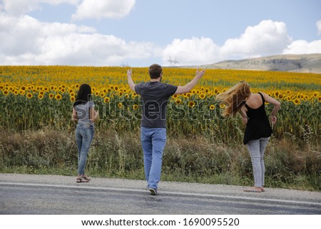 three friends on the sunflower field