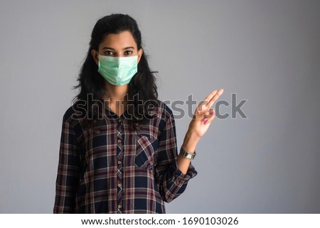 Young woman wearing medical face mask Showing sign. Woman wearing surgical mask for corona virus.